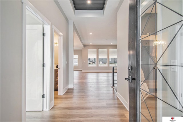 hall with hardwood / wood-style floors and a notable chandelier