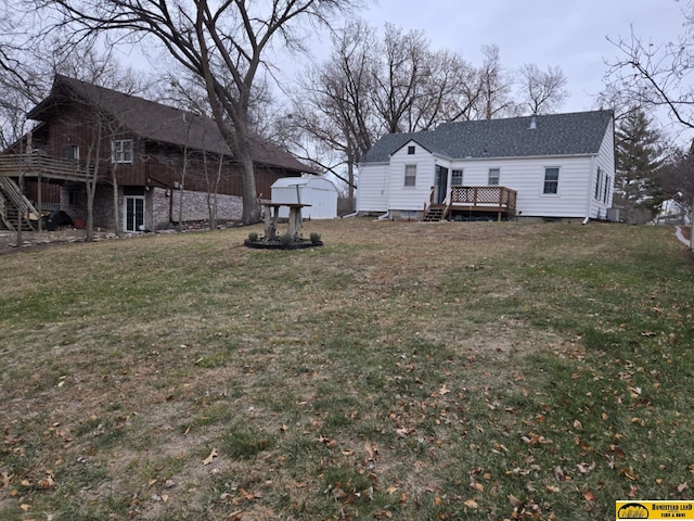 view of yard featuring a storage unit and a wooden deck