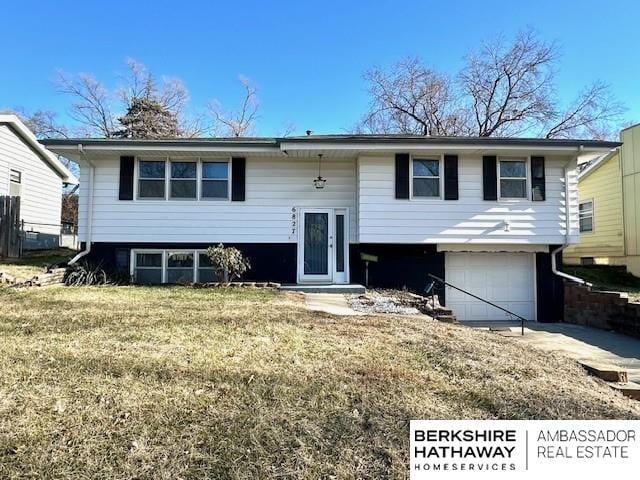 raised ranch with a front yard and a garage