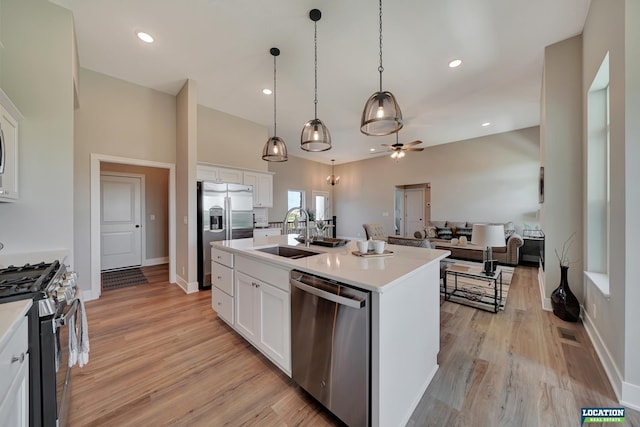 kitchen featuring pendant lighting, a center island with sink, white cabinets, sink, and appliances with stainless steel finishes