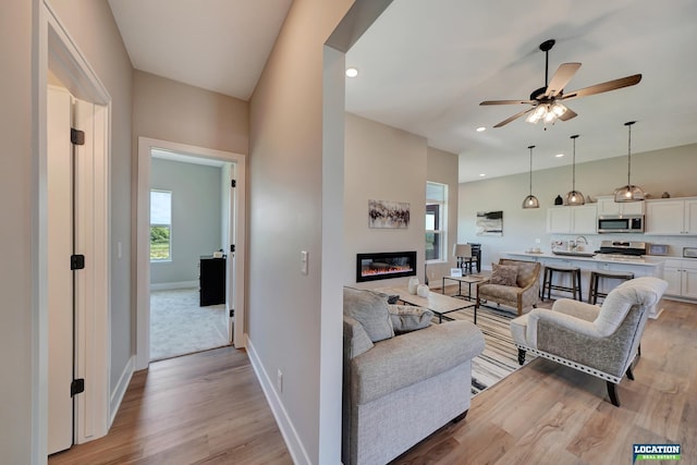 living room featuring ceiling fan and light wood-type flooring