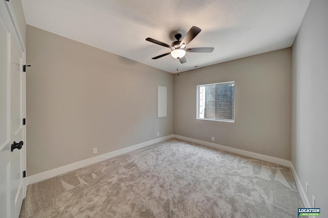 unfurnished room with ceiling fan, light colored carpet, and a textured ceiling