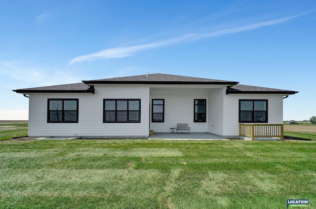 rear view of house featuring a lawn and a patio area