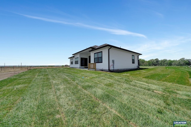 view of home's exterior with a yard and a rural view