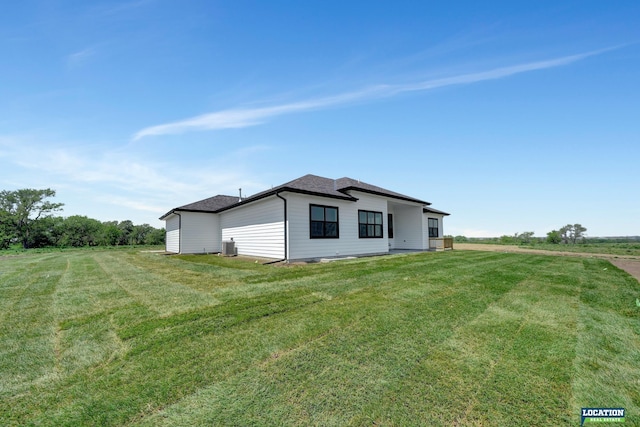 view of property exterior featuring central AC unit and a yard