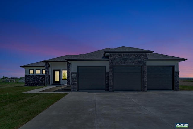 prairie-style house with a yard and a garage