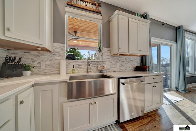 kitchen with backsplash, light hardwood / wood-style floors, white cabinetry, and sink