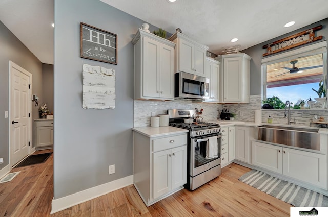 kitchen featuring light hardwood / wood-style floors, white cabinetry, sink, and appliances with stainless steel finishes