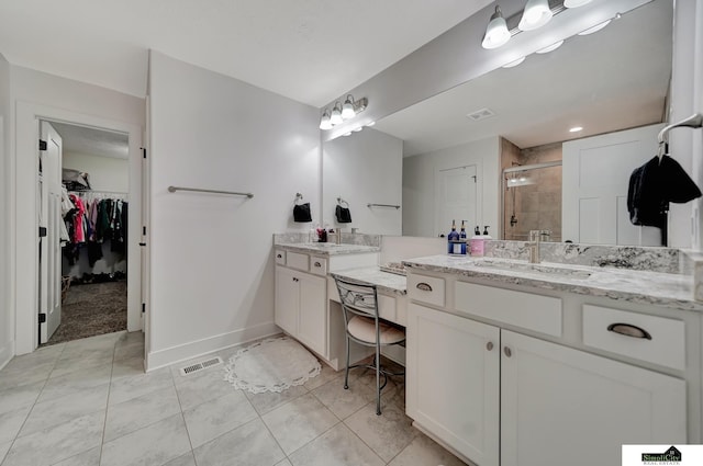 bathroom featuring tile patterned flooring, vanity, and a shower with door