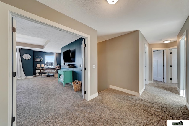 hall with carpet and a textured ceiling