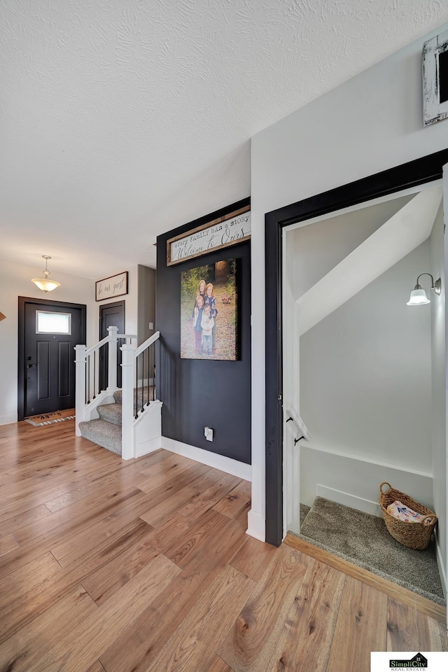 interior space with a textured ceiling and hardwood / wood-style flooring