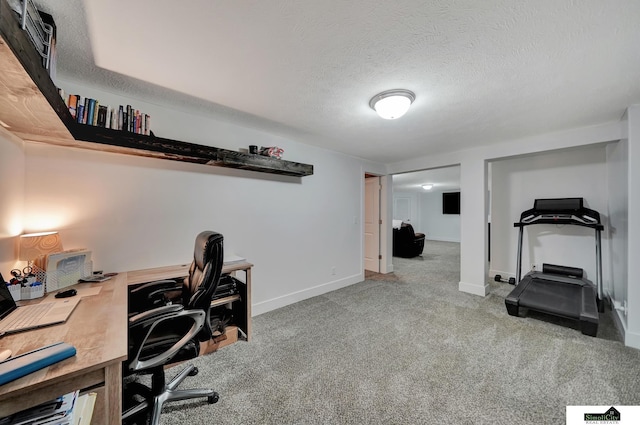 carpeted office space featuring a textured ceiling