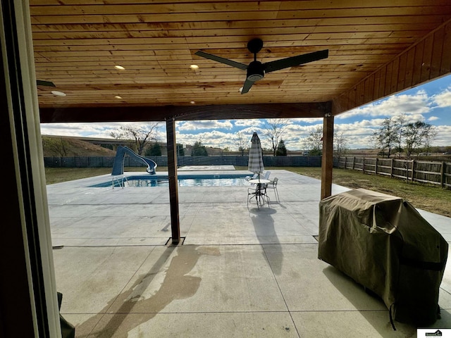 view of patio with a fenced in pool, ceiling fan, and a grill