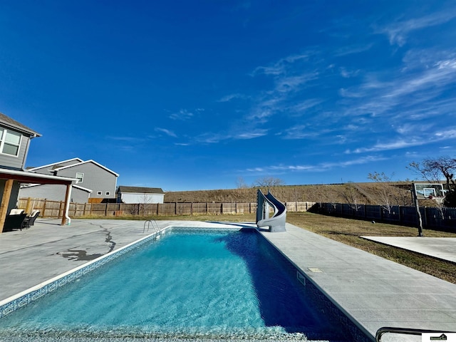 view of swimming pool with a water slide and a patio