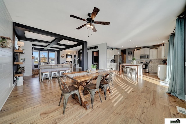 dining space featuring ceiling fan, beamed ceiling, coffered ceiling, and light wood-type flooring