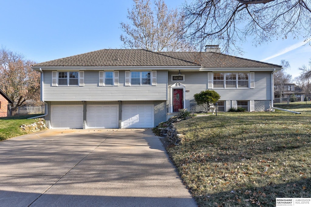 raised ranch with a garage and a front yard