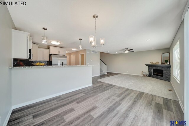 kitchen featuring white cabinetry, decorative backsplash, light hardwood / wood-style floors, kitchen peninsula, and stainless steel appliances