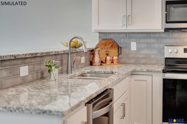 kitchen featuring white cabinets, range, dishwasher, and sink