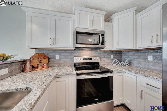 kitchen featuring a textured ceiling, white cabinetry, stainless steel appliances, and tasteful backsplash