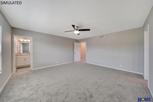 unfurnished bedroom with ceiling fan, light colored carpet, and ensuite bath