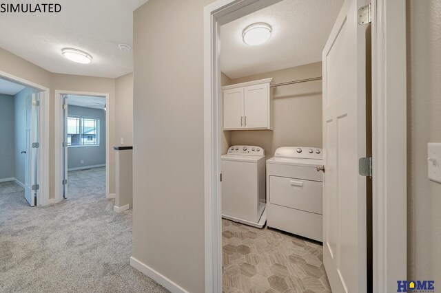 washroom featuring cabinets, light colored carpet, separate washer and dryer, and a textured ceiling