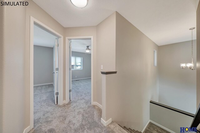 hall with a chandelier and light colored carpet