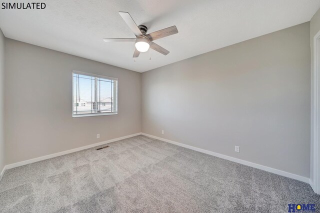 carpeted spare room featuring ceiling fan and a textured ceiling