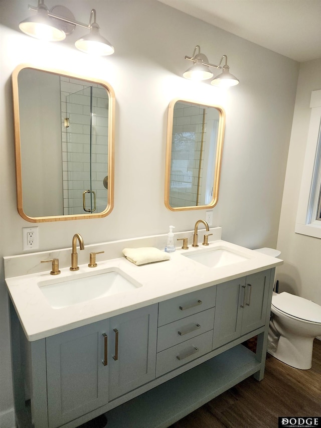 bathroom with hardwood / wood-style floors, vanity, toilet, and an enclosed shower