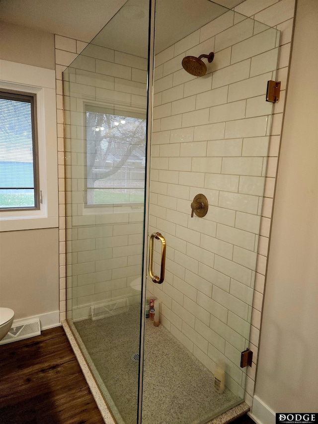 bathroom with walk in shower, toilet, and hardwood / wood-style flooring