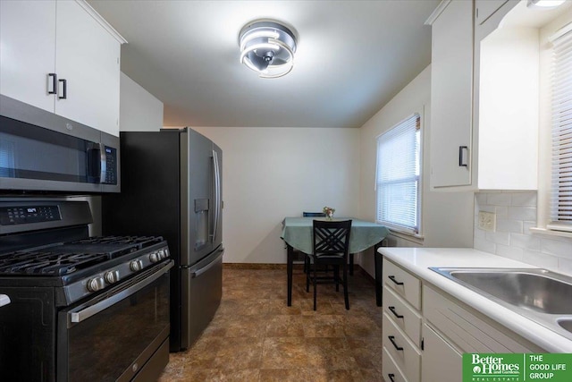 kitchen featuring backsplash, sink, white cabinets, and stainless steel appliances