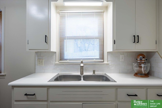 kitchen with white cabinets, decorative backsplash, and sink