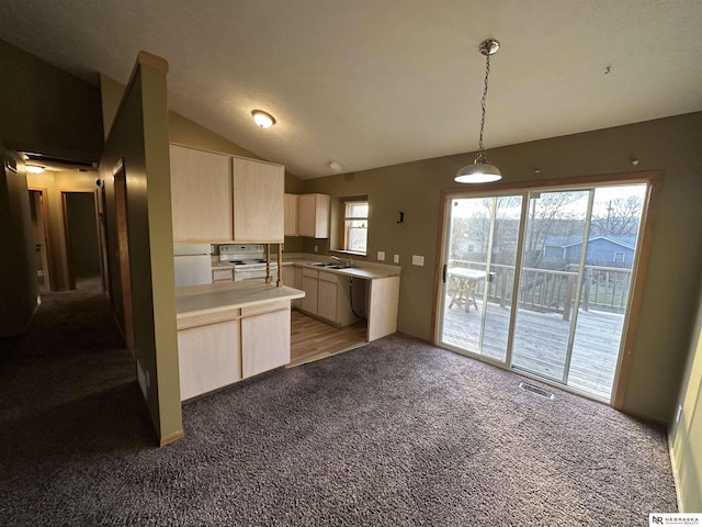 kitchen featuring carpet flooring, light brown cabinets, lofted ceiling, and hanging light fixtures