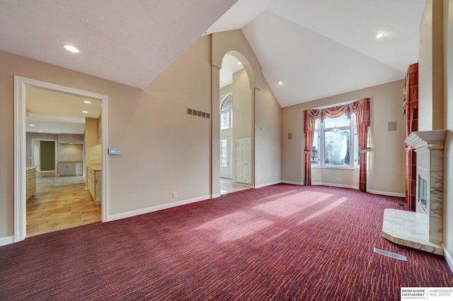 unfurnished living room featuring light carpet and high vaulted ceiling