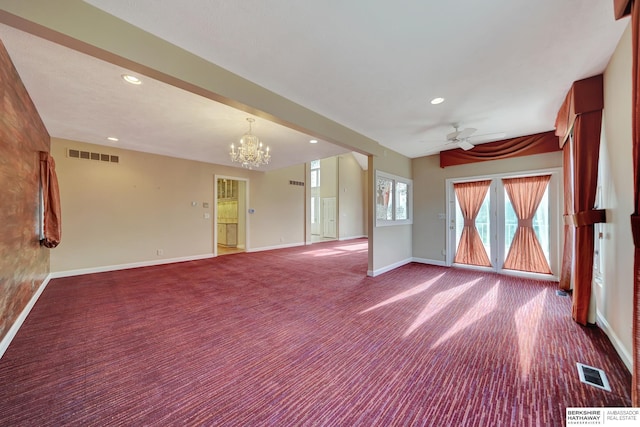 carpeted empty room featuring ceiling fan with notable chandelier