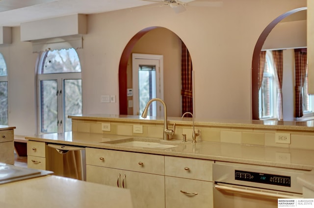 kitchen featuring cream cabinetry, ceiling fan, dishwasher, and sink