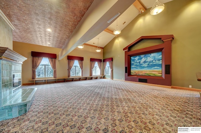 cinema room featuring carpet flooring, a tile fireplace, beamed ceiling, and high vaulted ceiling