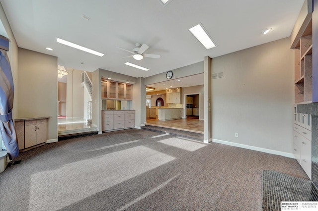 unfurnished living room featuring carpet and ceiling fan