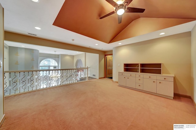 carpeted spare room featuring ceiling fan and vaulted ceiling