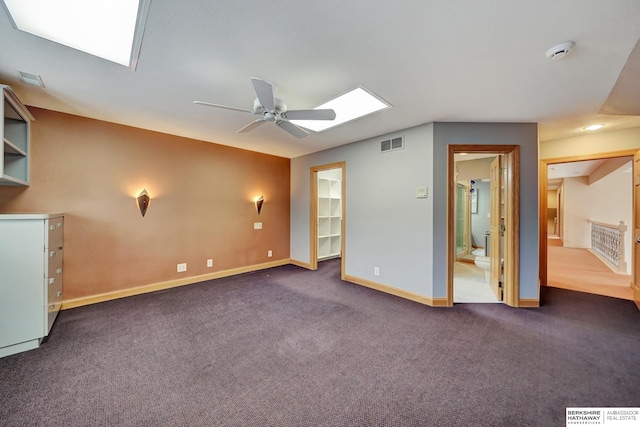 spare room featuring ceiling fan and dark colored carpet