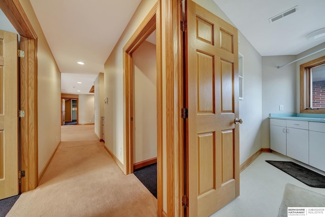 hallway featuring light colored carpet