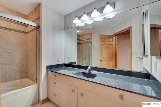 bathroom featuring combined bath / shower with glass door and vanity