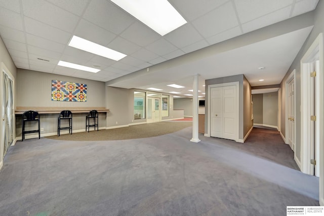 basement featuring carpet and a paneled ceiling