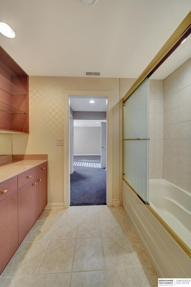 bathroom with tile patterned flooring and shower / bath combination with glass door