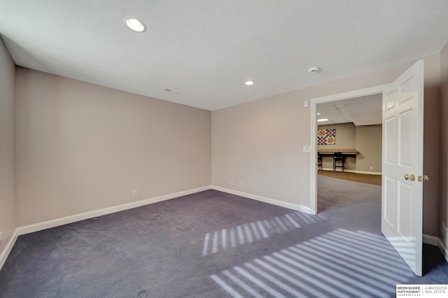 carpeted empty room with a textured ceiling