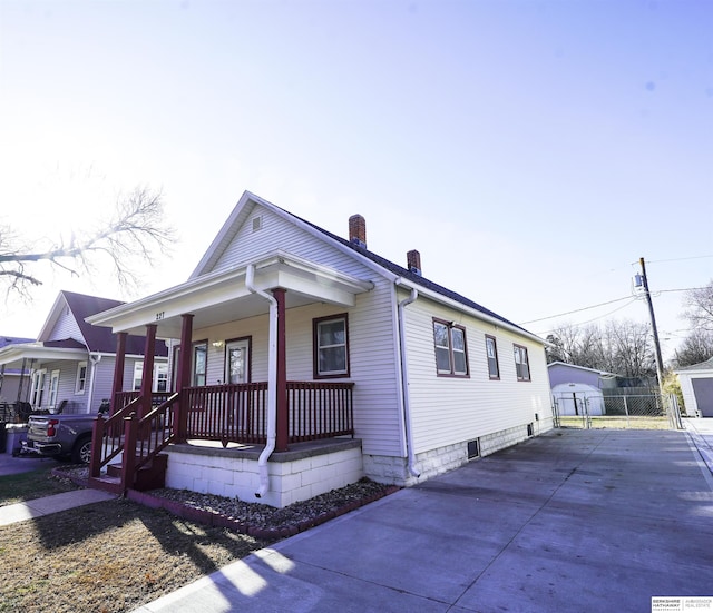 view of front of home with a garage, covered porch, and an outdoor structure