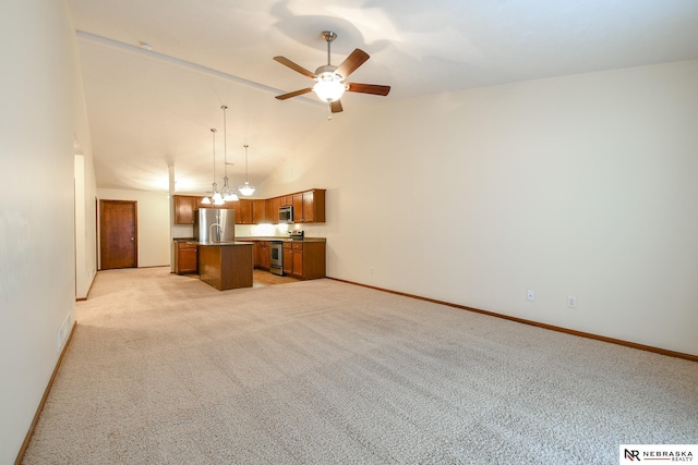 kitchen with light carpet, appliances with stainless steel finishes, ceiling fan with notable chandelier, a kitchen island, and hanging light fixtures