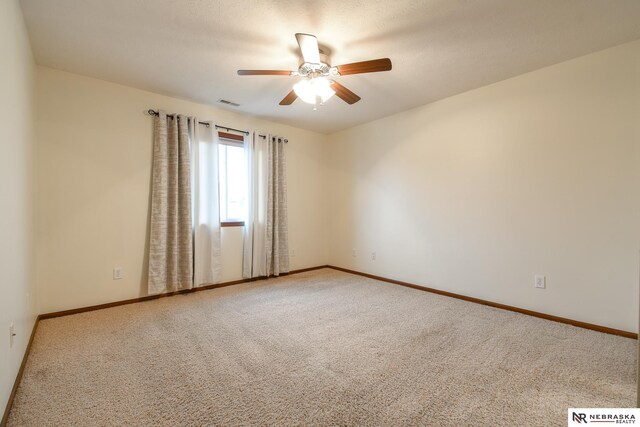 spare room featuring carpet flooring, ceiling fan, and a textured ceiling