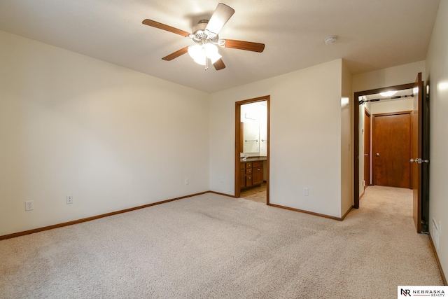 unfurnished bedroom featuring ceiling fan, light carpet, and connected bathroom