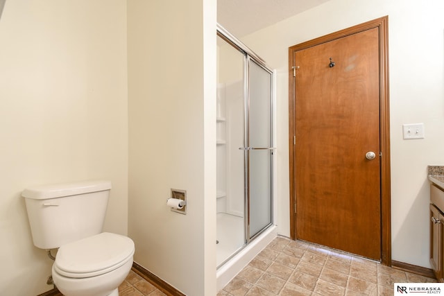 bathroom with vanity, toilet, and a shower with shower door