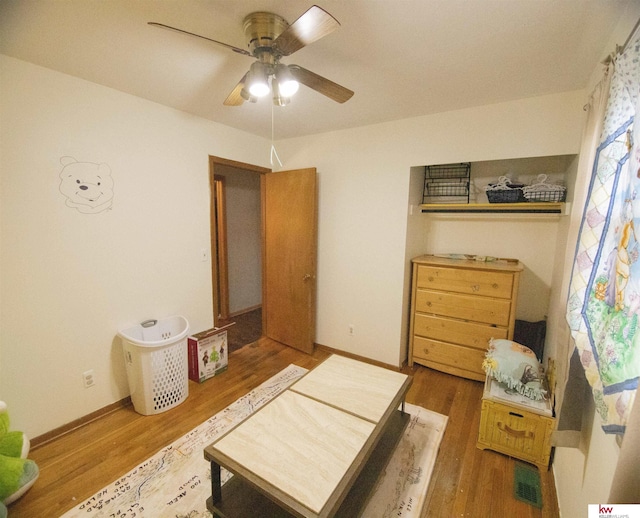 living area featuring hardwood / wood-style floors and ceiling fan